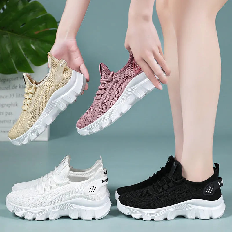 Women's white Flyknit lace-up sneakers with a thick PVC sole and round toe on a neutral background.