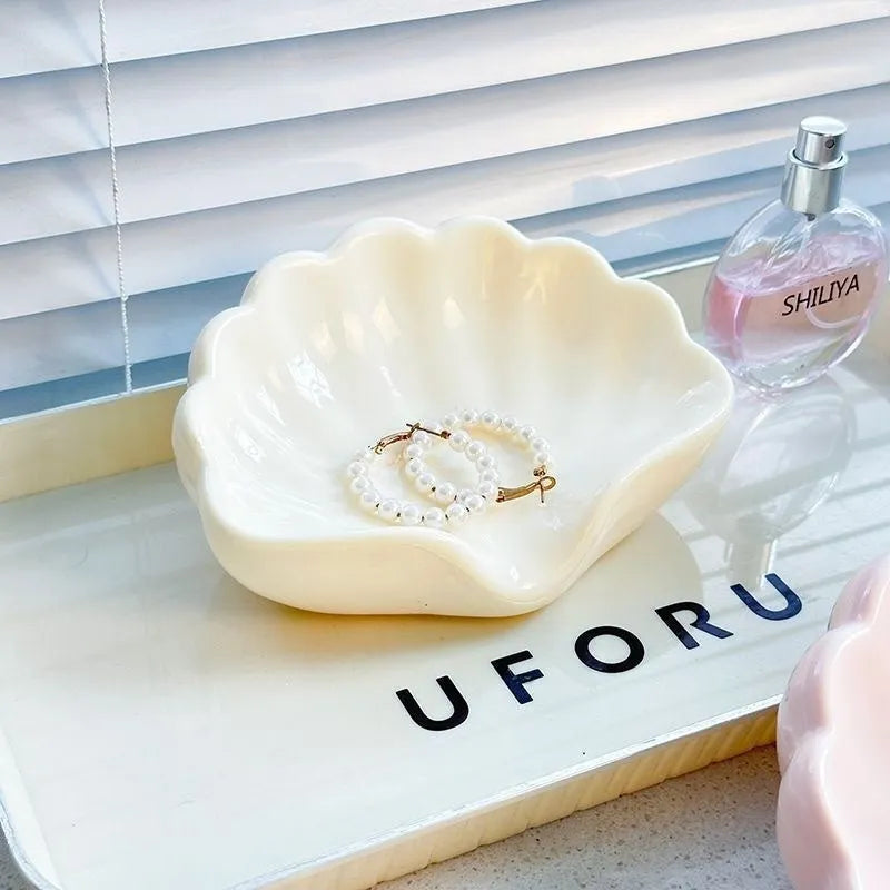 White and pink plastic shell-shaped soap dish for bathroom counter.