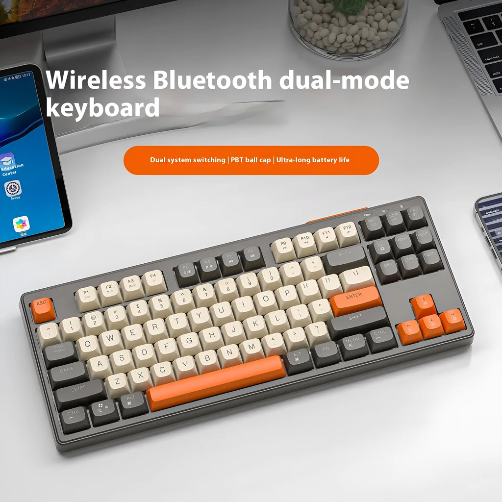 Free Wolf M87 wireless Bluetooth dual-mode mechanical feel keyboard in one of four colour options on a desk.