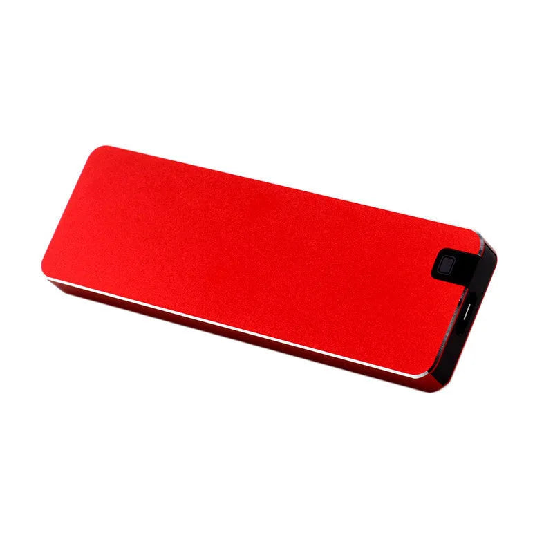 White portable external SSD with metal shell and USB cable next to a laptop.