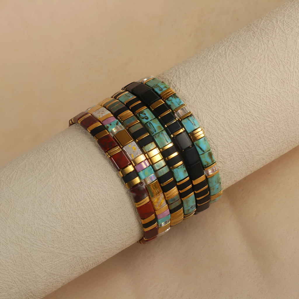 Geometric glass and coloured glaze beaded bracelet with a pull clasp in milky white colour.
