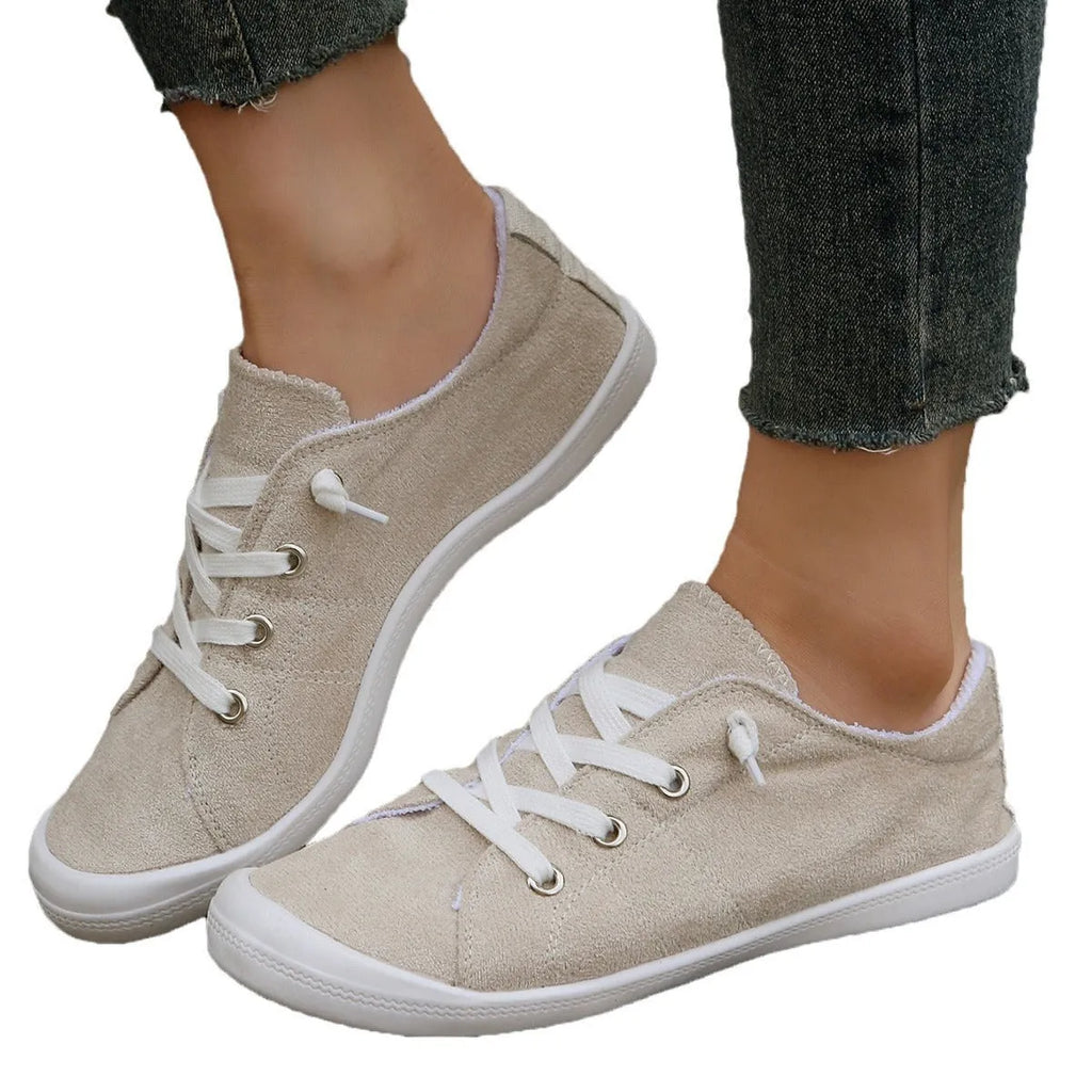 Women's creamy-white low-top fabric casual sneakers with a rubber sole on a neutral background.