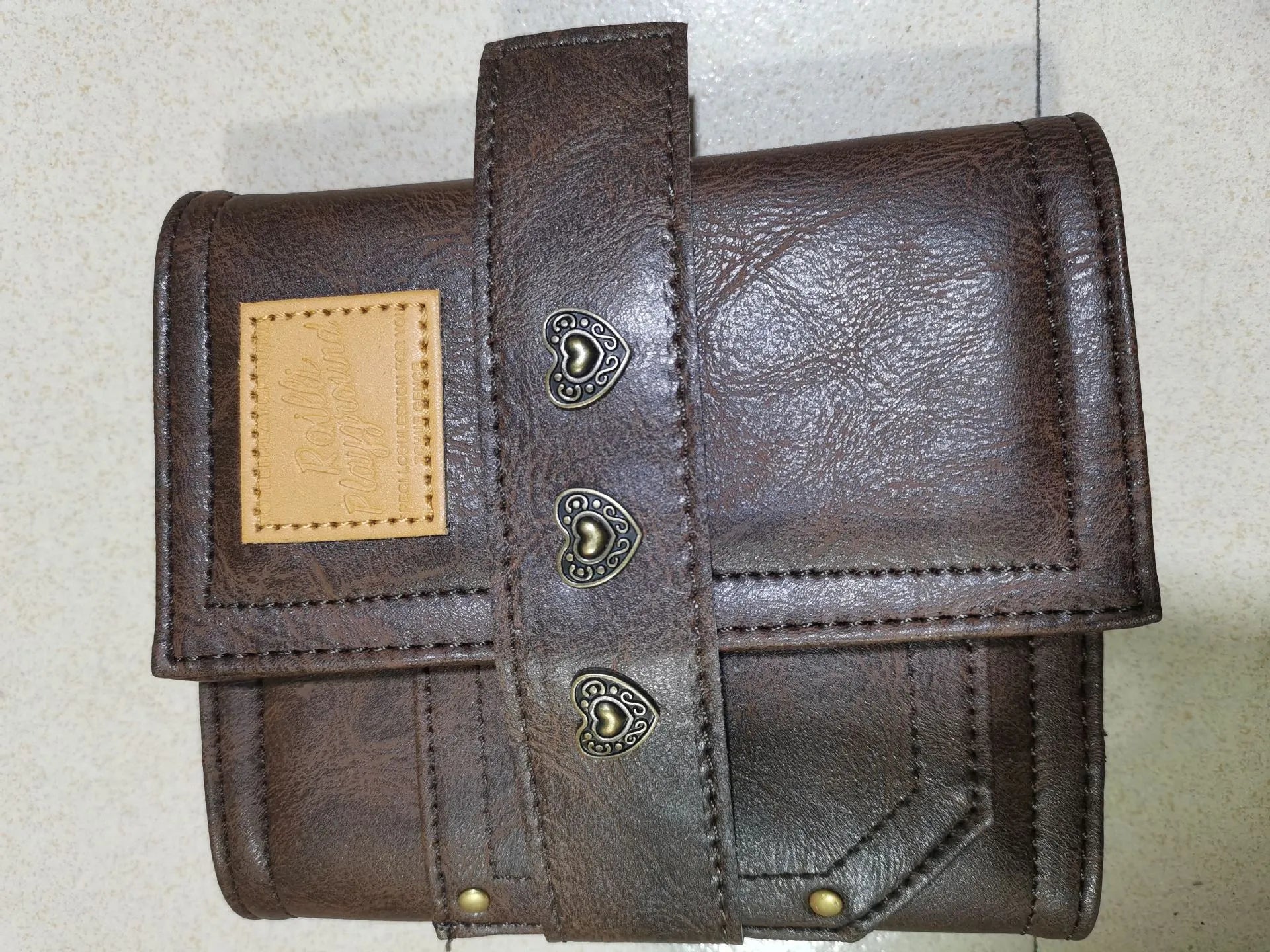 Brown A7 PU leather buckle notebook with loose-leaf binder binding on wooden surface