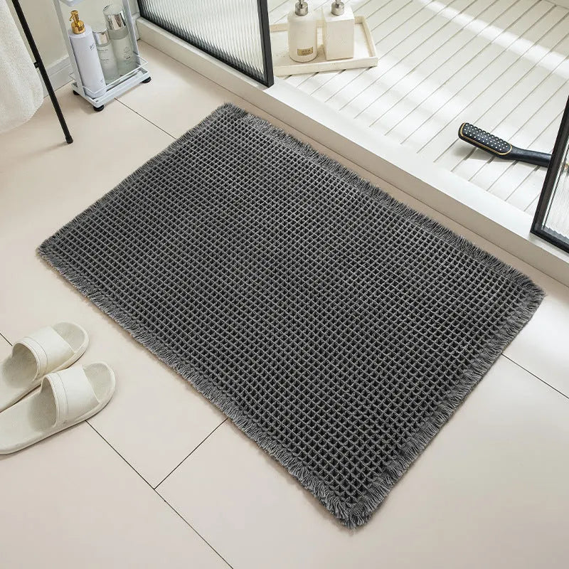 Checkered patterned non-slip absorbent bathroom floor mat in a neutral colour on tiles.