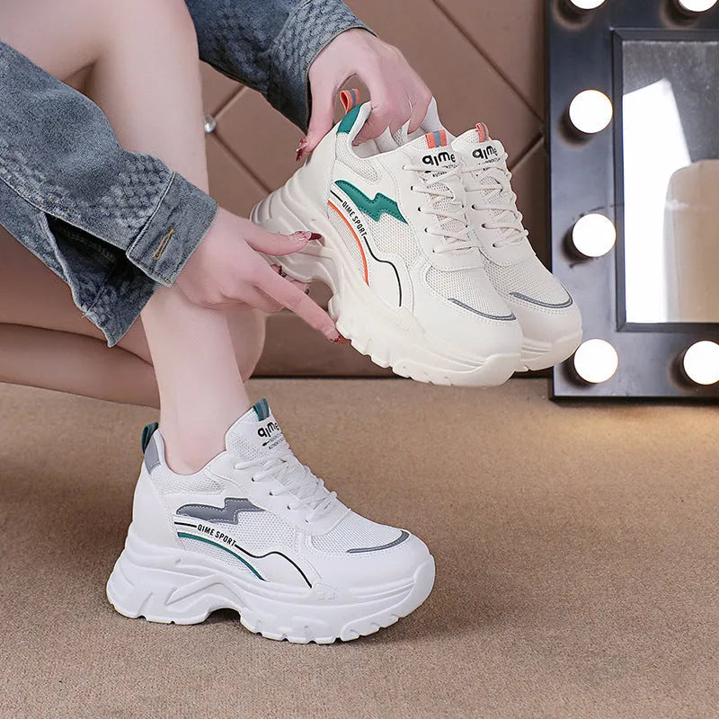 White women's low-top sports trainers with a front lace-up and cross-strap detail.
