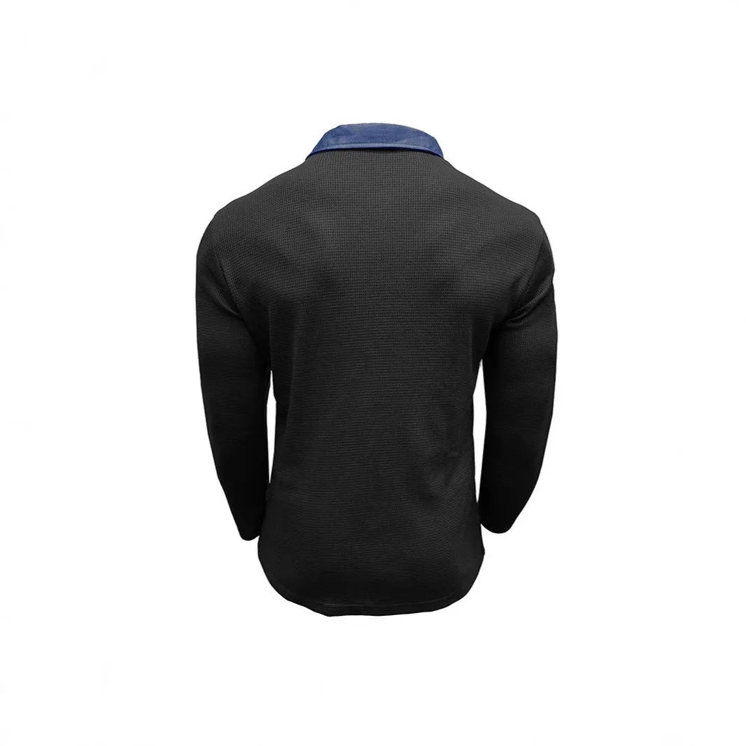 Man wearing a loose-fit long-sleeved polo shirt with a waffle knit texture in a dark blue colour.