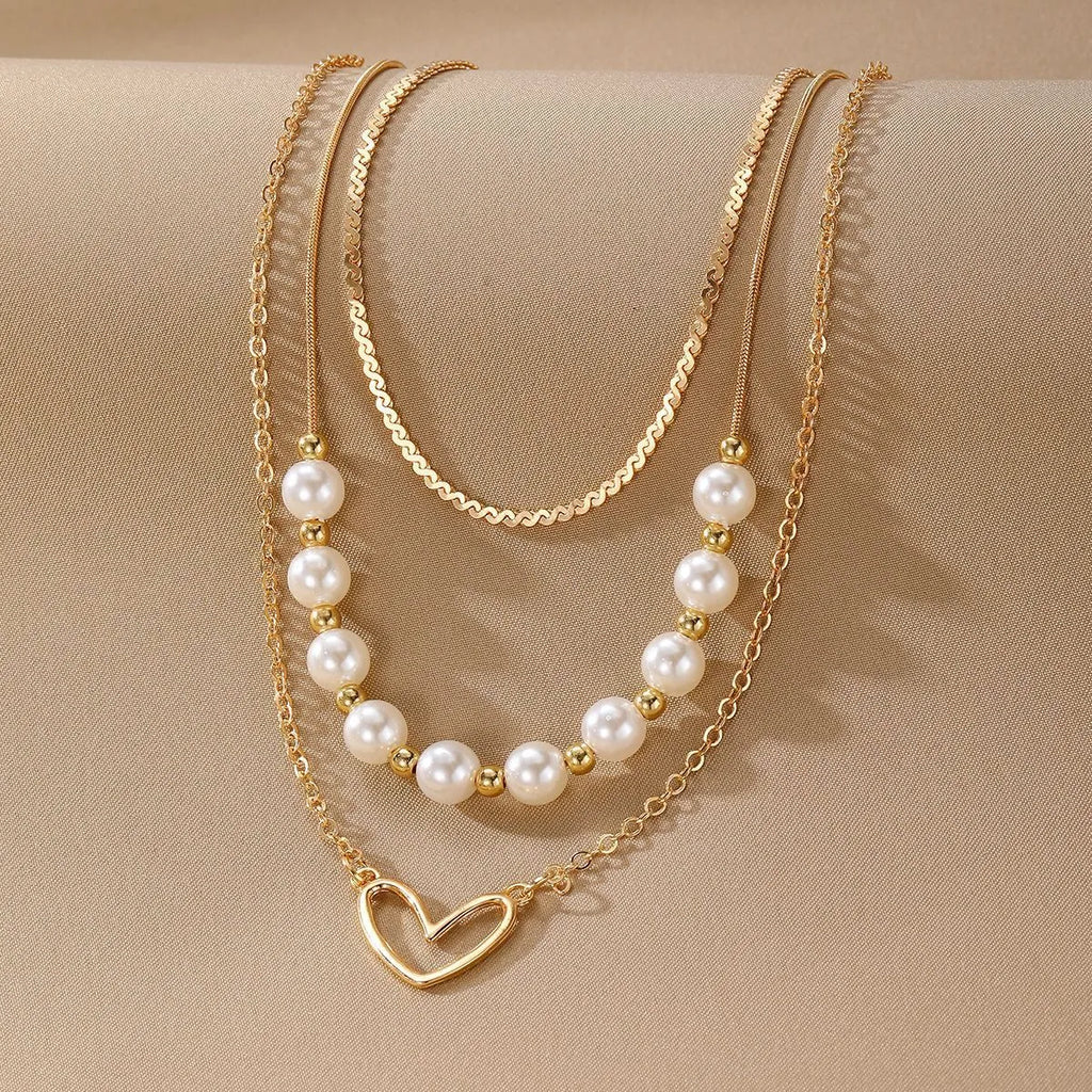 Gold electroplated vintage necklace with heart-shaped pendant on an adjustable pearl-style chain.