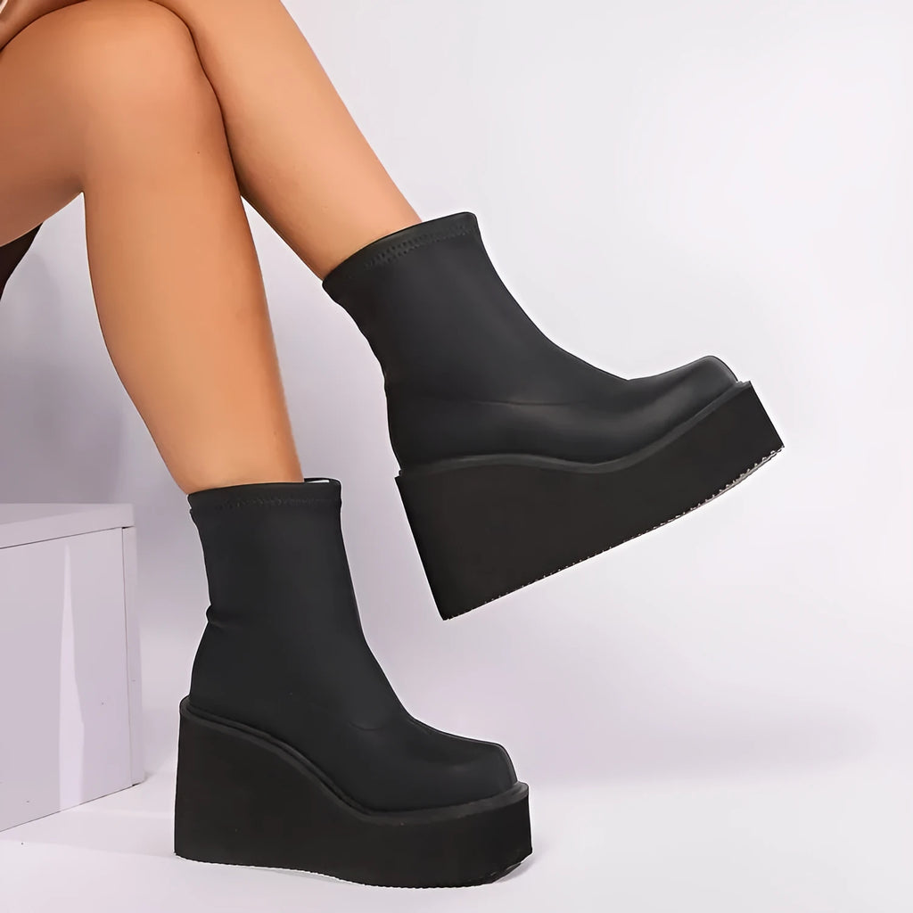 Plus size black wedge heel boots with a waterproof platform and round toe on a white background.