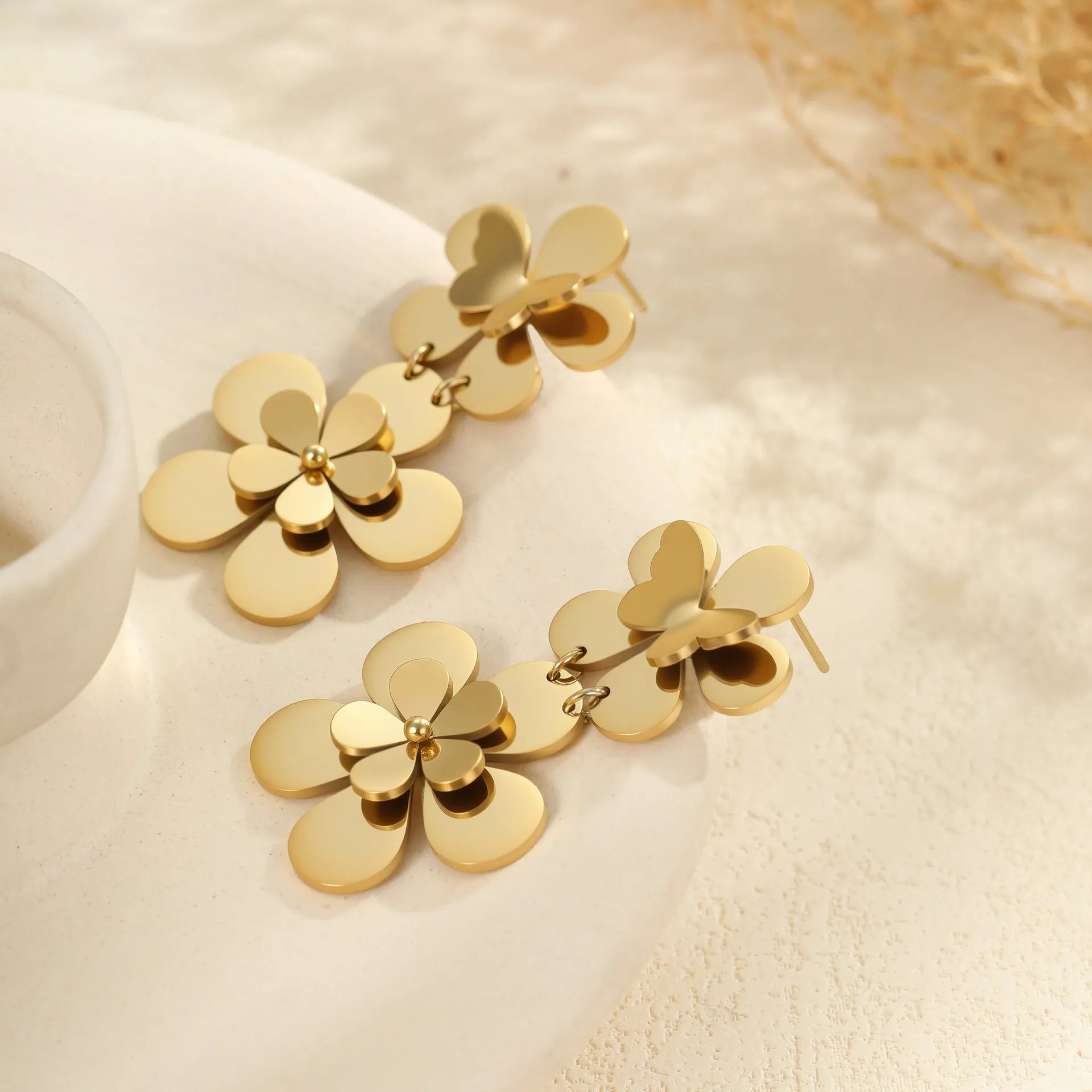 Gold-coloured flower butterfly earrings with geometric design elements on stainless steel