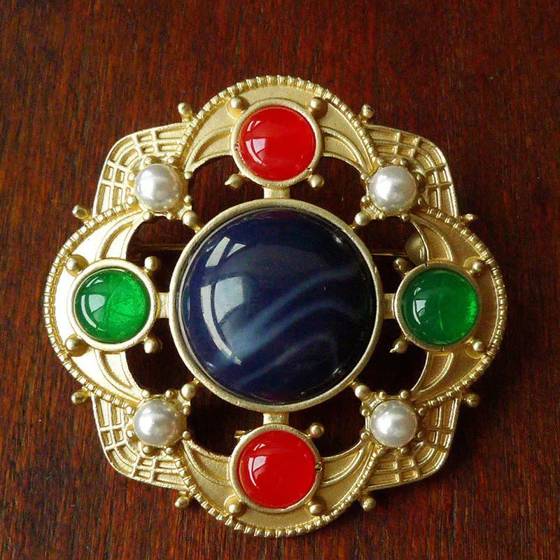 A selection of eight different zinc alloy retro baroque brooches in a diamond shape on a fabric background.
