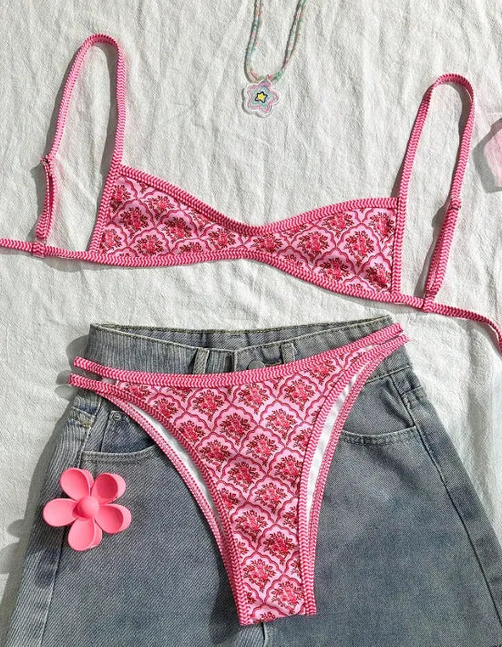 Printed pink split bikini set with exposed back and adjustable shoulder straps on woman