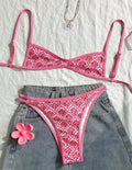 Printed pink split bikini set with exposed back and adjustable shoulder straps on woman