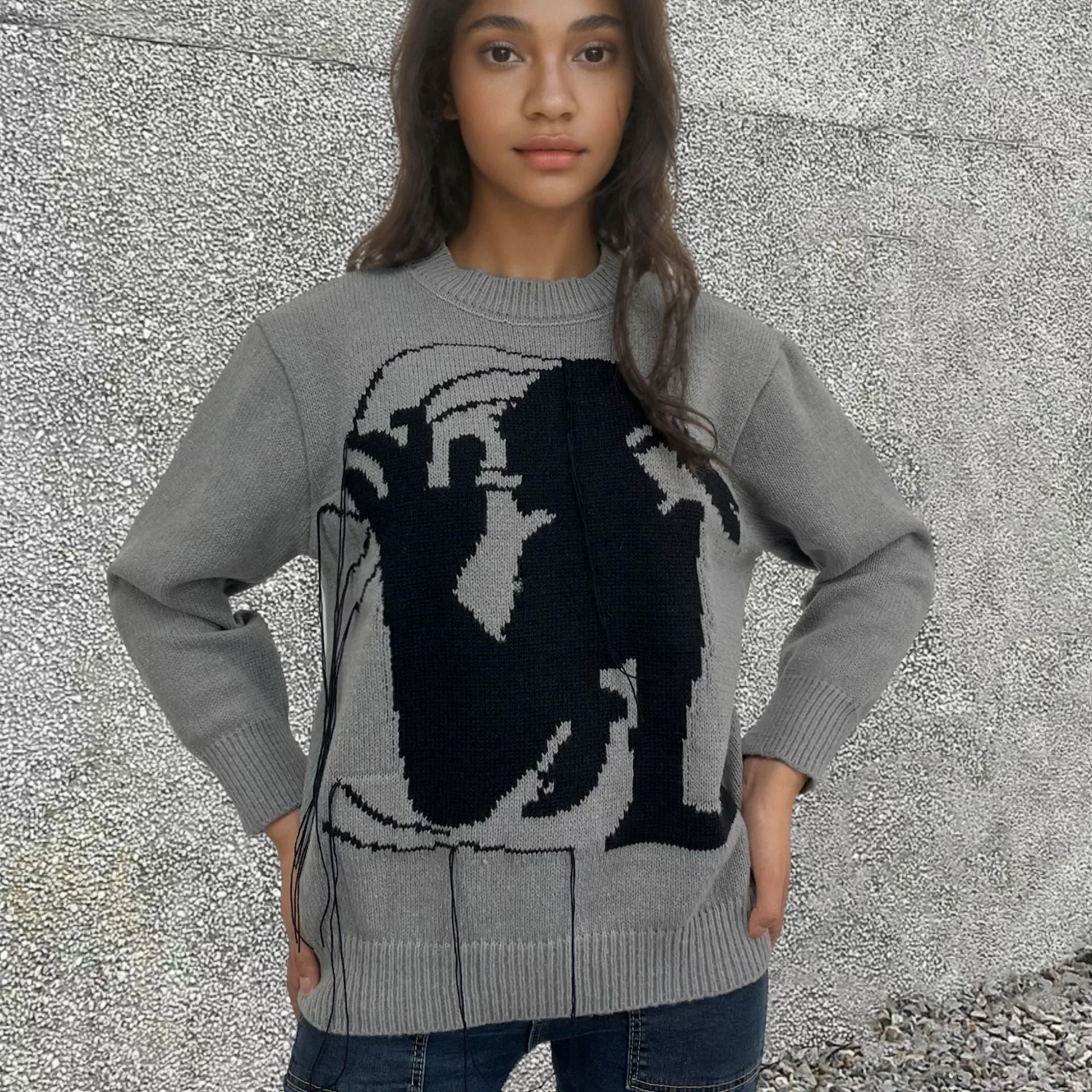 Grey and white women's alpaca wool sweater with tassel detail and abstract pattern.