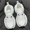 Beige mesh platform sports shoe with a wedge heel and front lace-up design on a white background.