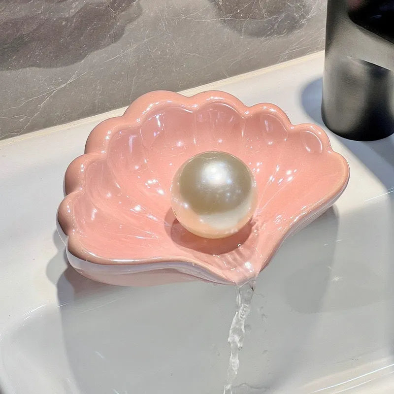 White and pink plastic shell-shaped soap dish for bathroom counter.