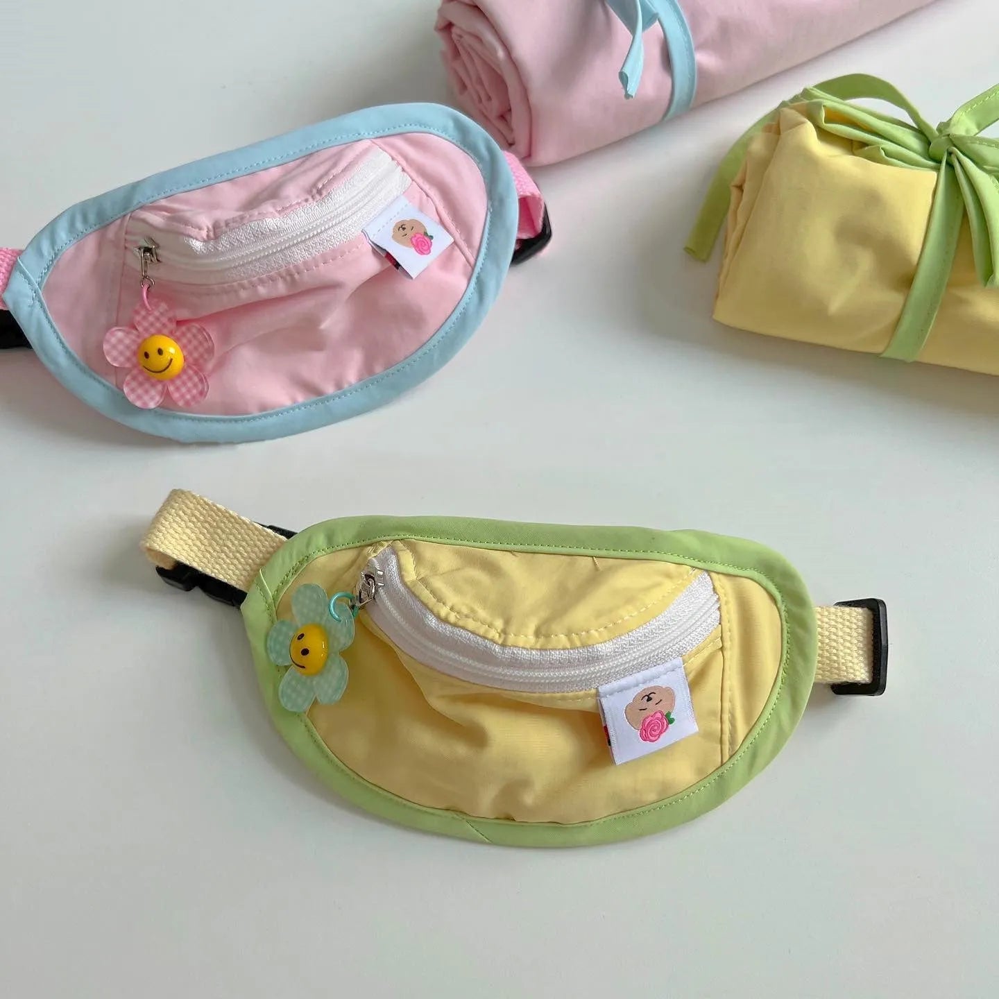 Pink or yellow backpack-style pet carrier for small dogs and cats with adjustable straps and attached poop bag holder.