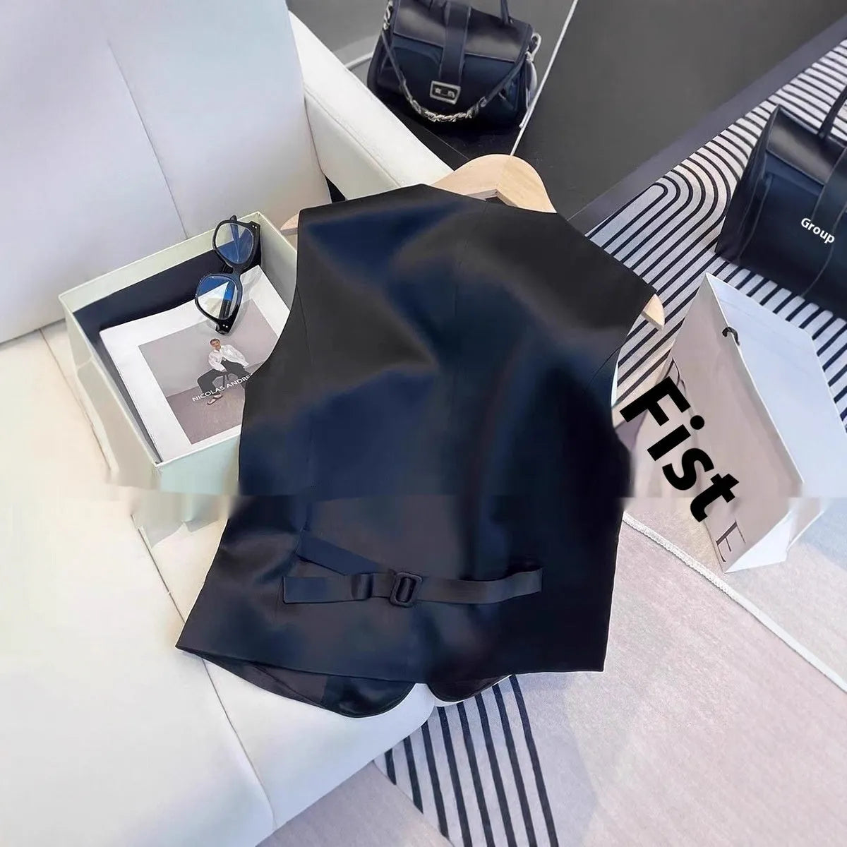 Black sleeveless satin vest for women on a hanger, showing loose fit and normal length.