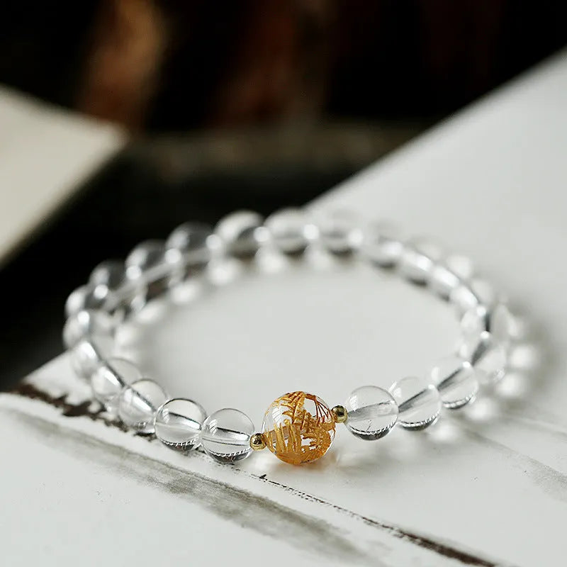 Geometric obsidian and white crystal bracelet with black agate beads and golden dragon charm on wrist