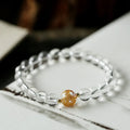 Geometric obsidian and white crystal bracelet with black agate beads and golden dragon charm on wrist