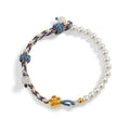 Peach-coloured Chinese flower weaving carrying strap bracelet with pearl accents on cord material