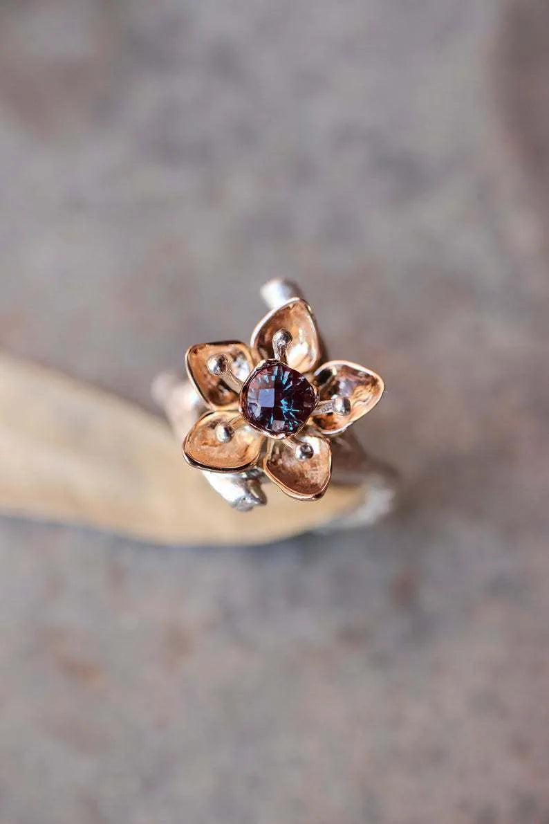 Silver two-tone women's ring with geometric shape and floral detailing on a hand.