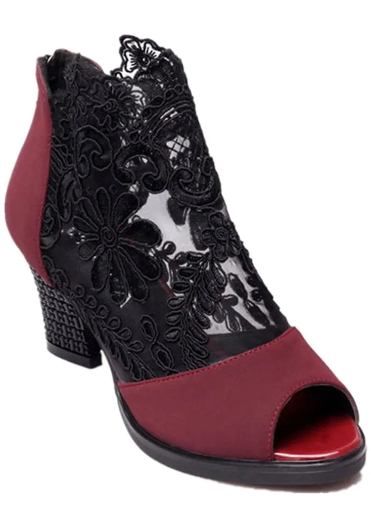 Black women's lace gladiator sandals with a zip closure, floral pattern, and a square high heel on a rubber outsole.