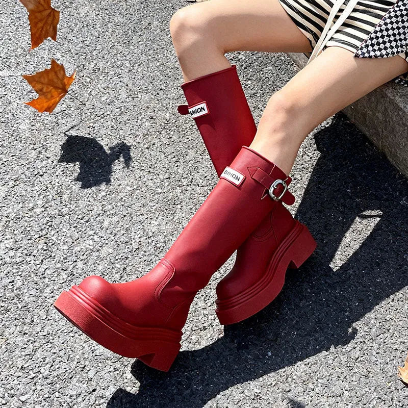 Black knight boots with thick platform sole and chunky heel, front view, showing round toe and high cylinder shaft.