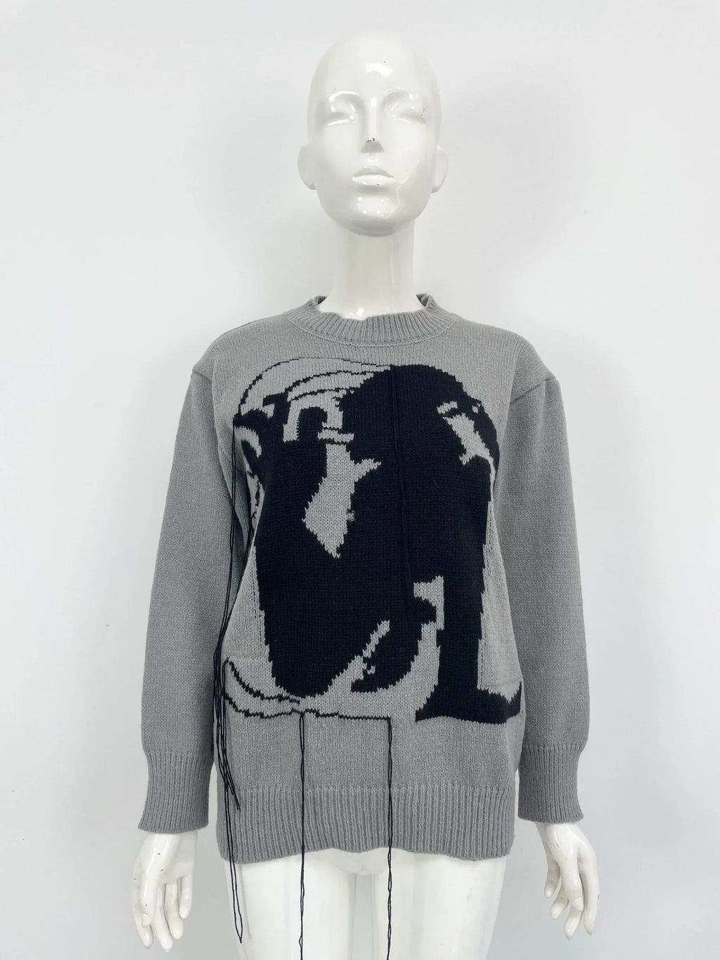 Grey and white women's alpaca wool sweater with tassel detail and abstract pattern.