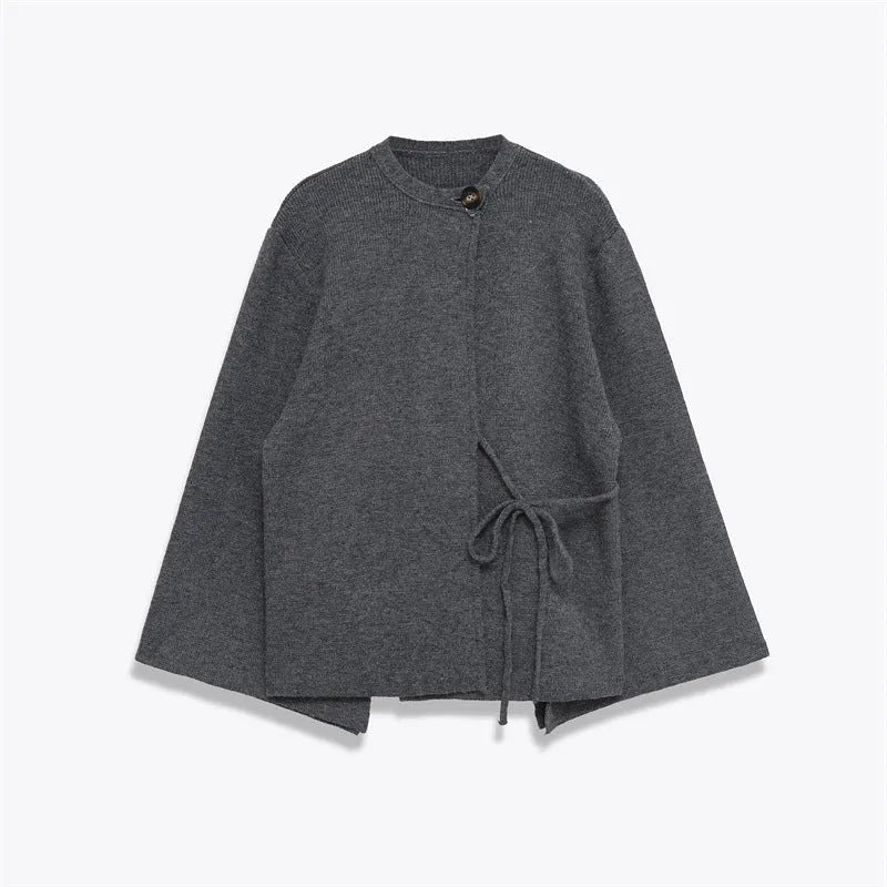 Women's long gray knitted coat with slit sleeves and pockets on display