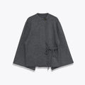 Women's long gray knitted coat with slit sleeves and pockets on display