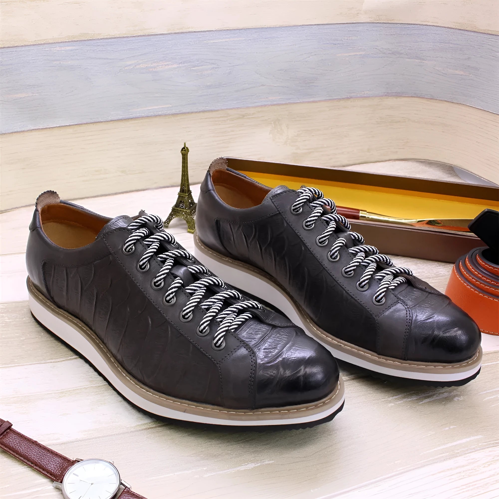 Men's black low-top sneakers with an embossed pattern and white laces.