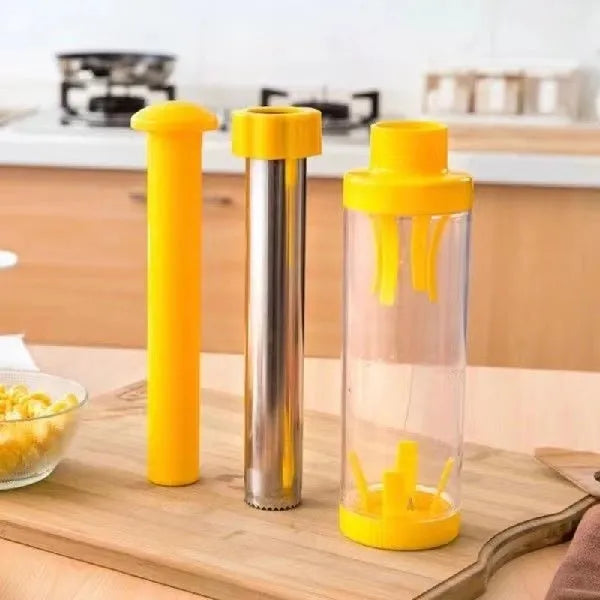 Yellow manual corn stripper thresher with stainless steel construction on a kitchen worktop.