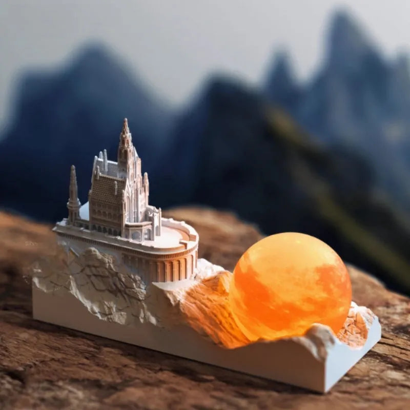 Mountain-shaped night light with LED touch control, essential oil bottle, and gift card on a wooden desk