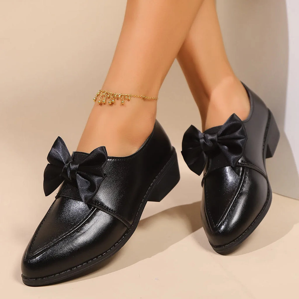 Women's British-style leather-look slip-on shoes with a decorative bow on the front