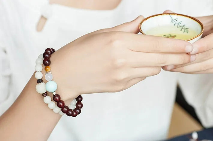 Natural white jade Bodhi bracelet with transfer beads on a neutral background