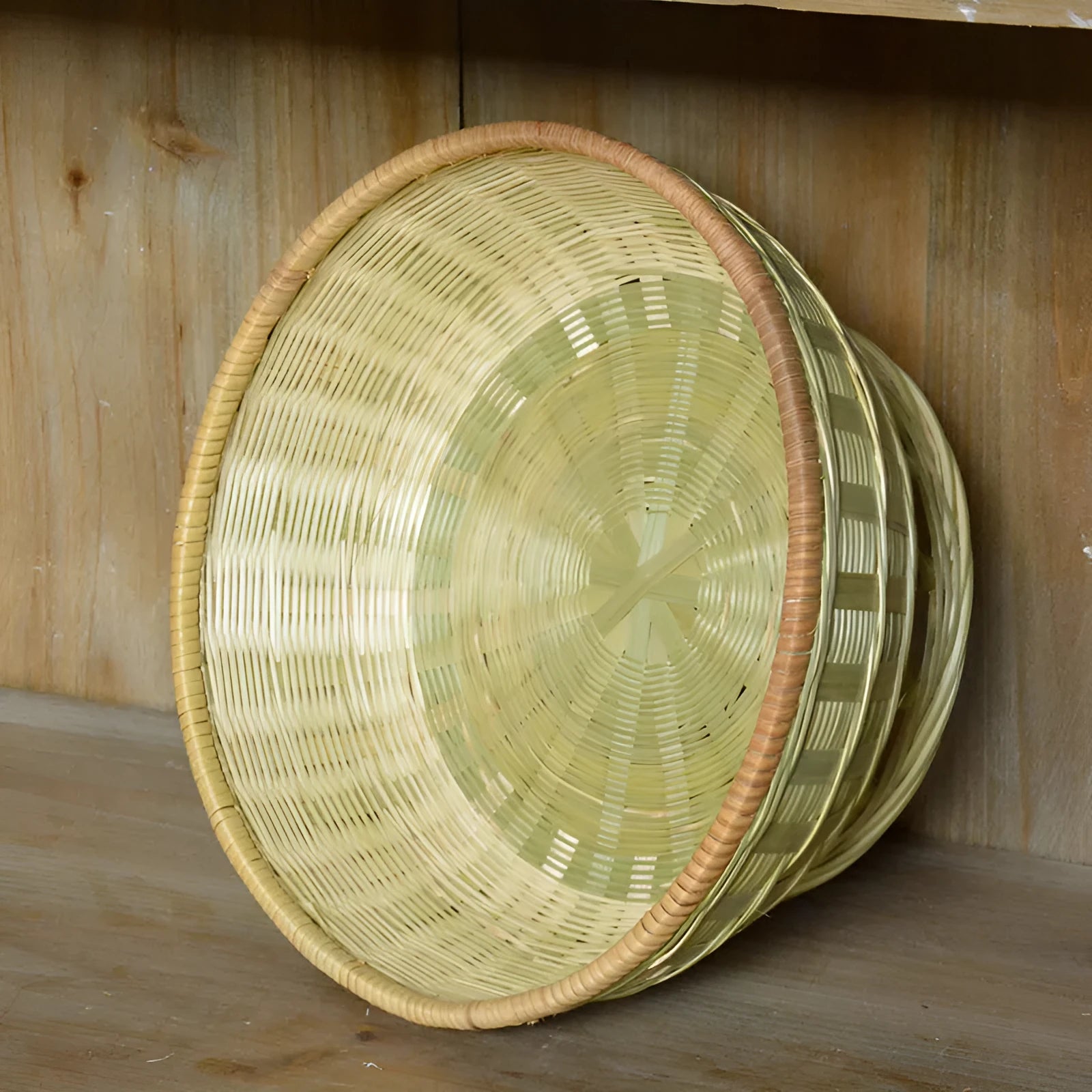 Handmade woven natural bamboo storage basket shown in a household setting.