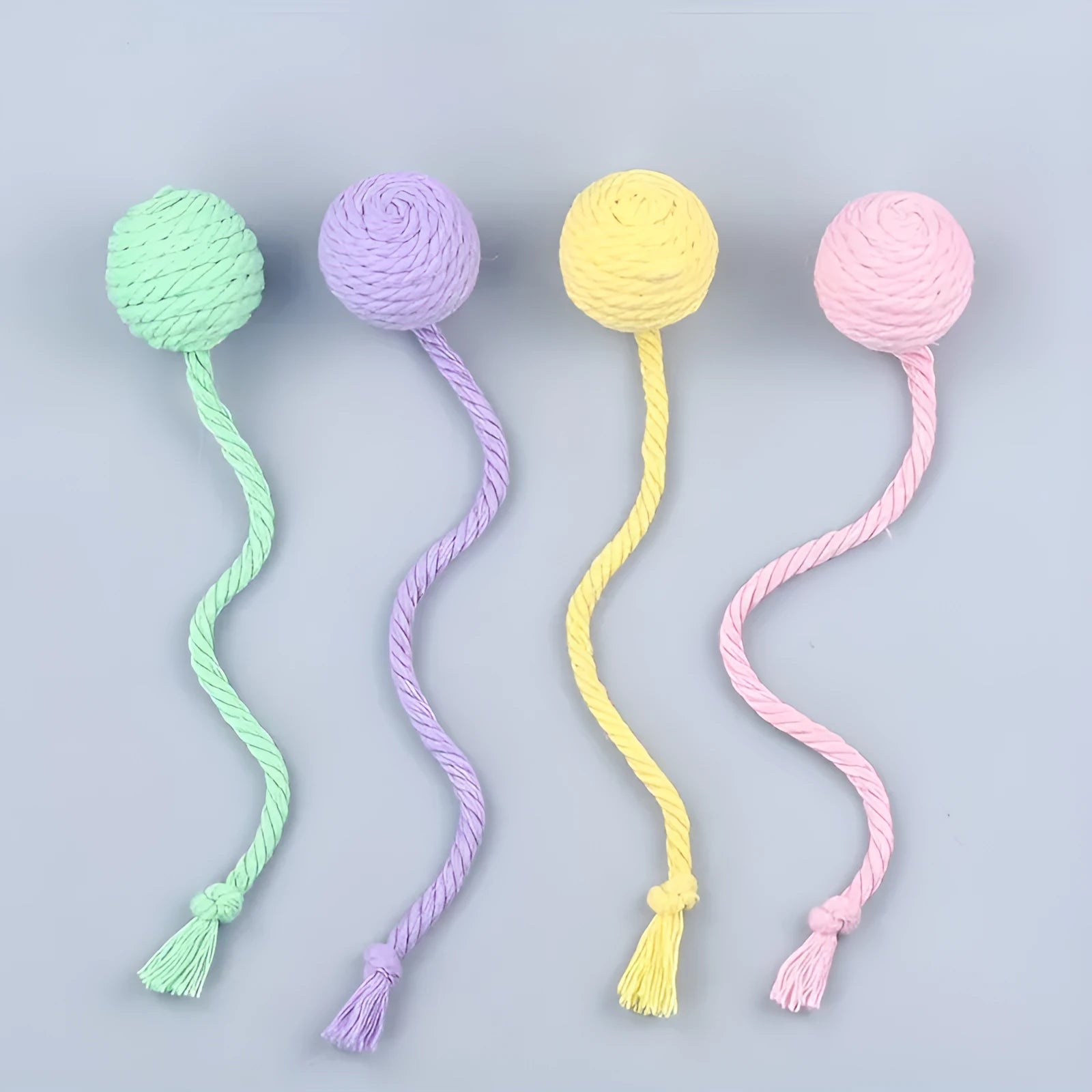 Cat toy ball with rope attached in green, pink, purple, or yellow colours with internal bell