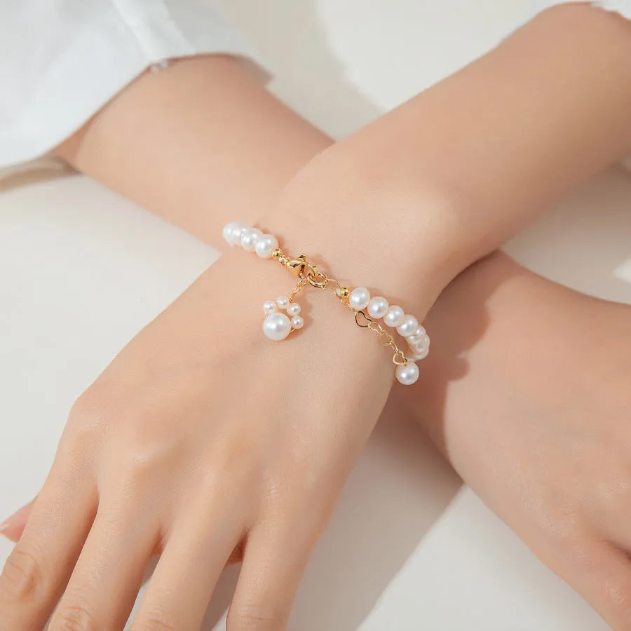Women's white freshwater pearl cat's paw bracelet with electroplating finish on a neutral background