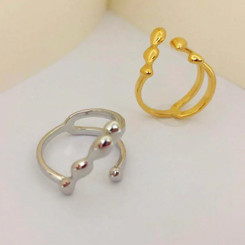 Gold and silver brass opening ring with sphere circle design on a woman's hand.