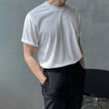 Men's slim fit solid colour cotton t-shirt on a model, showing round neck and half sleeves in white or black.