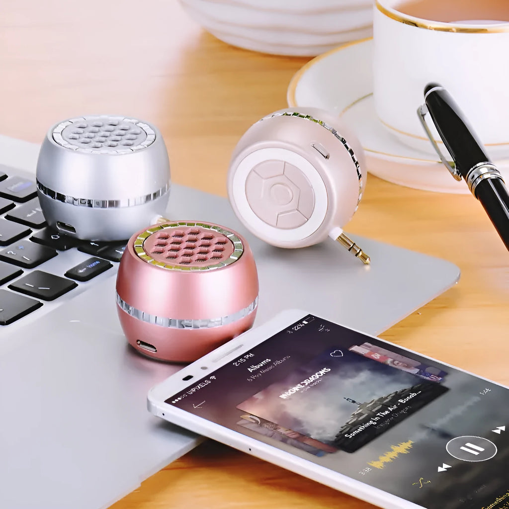 Black universal external amplifier speaker with a single channel, powered by a 5V mobile phone charger.