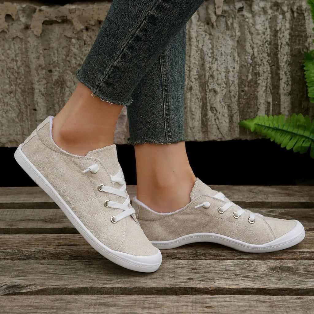 Women's creamy-white low-top fabric casual sneakers with a rubber sole on a neutral background.