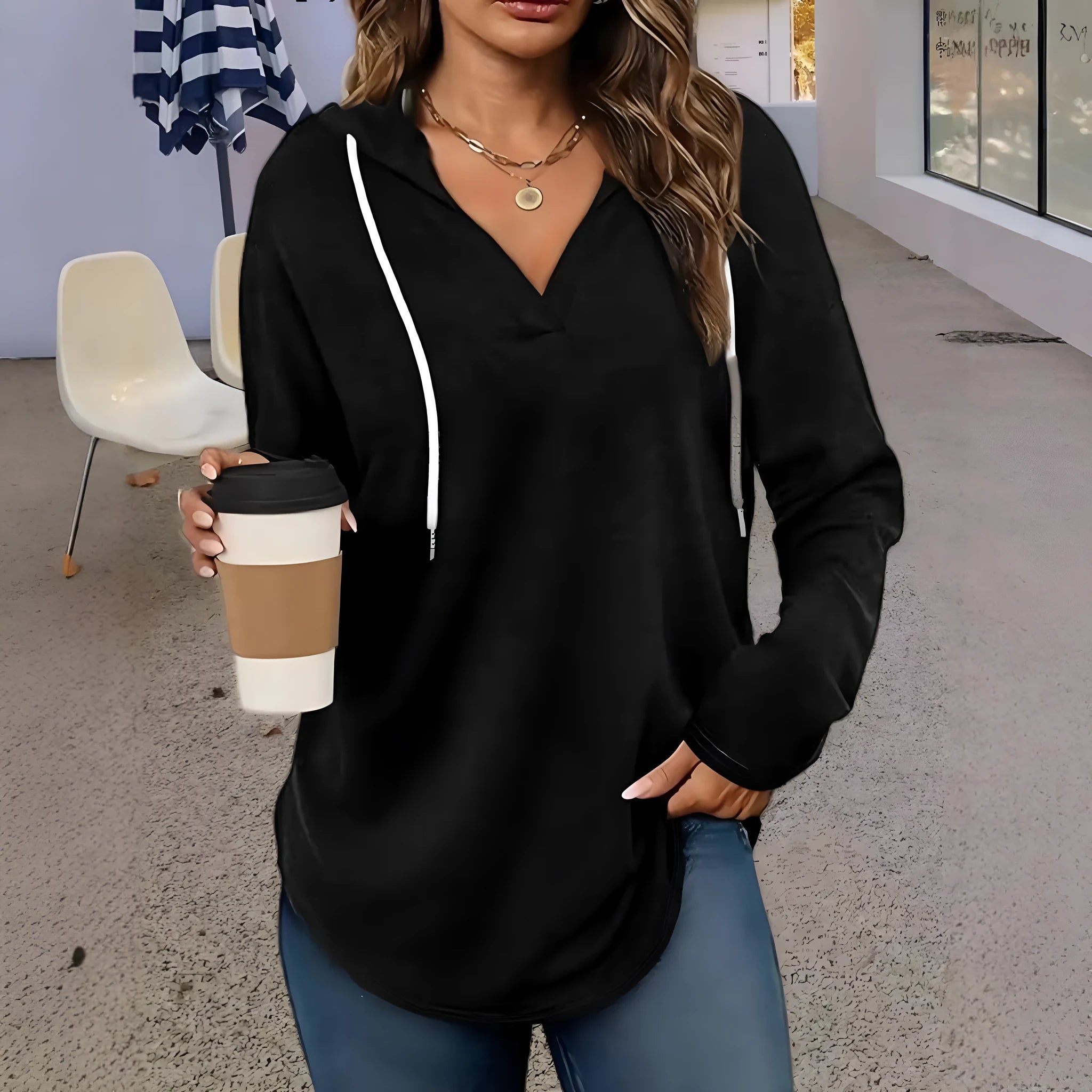A woman wearing a red V-neck hooded sweatshirt with long sleeves, shown in a loose fit.
