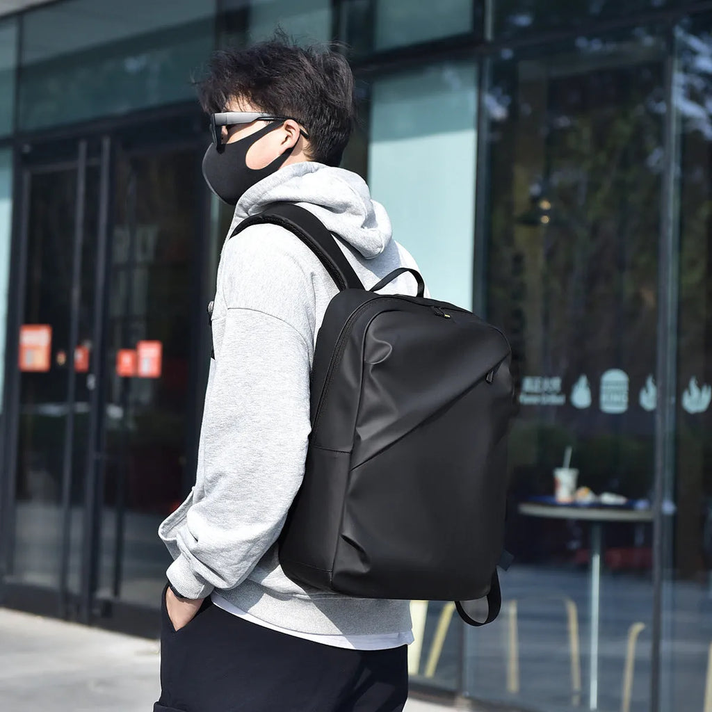 Men's large capacity waterproof backpack in black colour showing PU leather construction and computer bag accommodation
