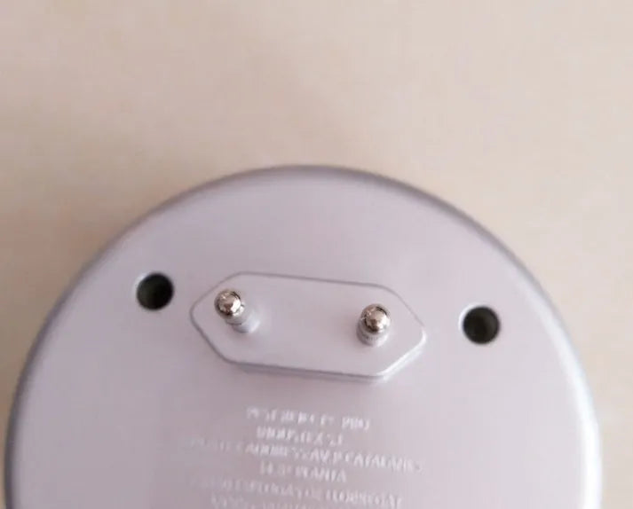 Silver grey intelligent ultrasonic mosquito repellent measuring 10cm, plugged into a white wall socket for indoor pest control