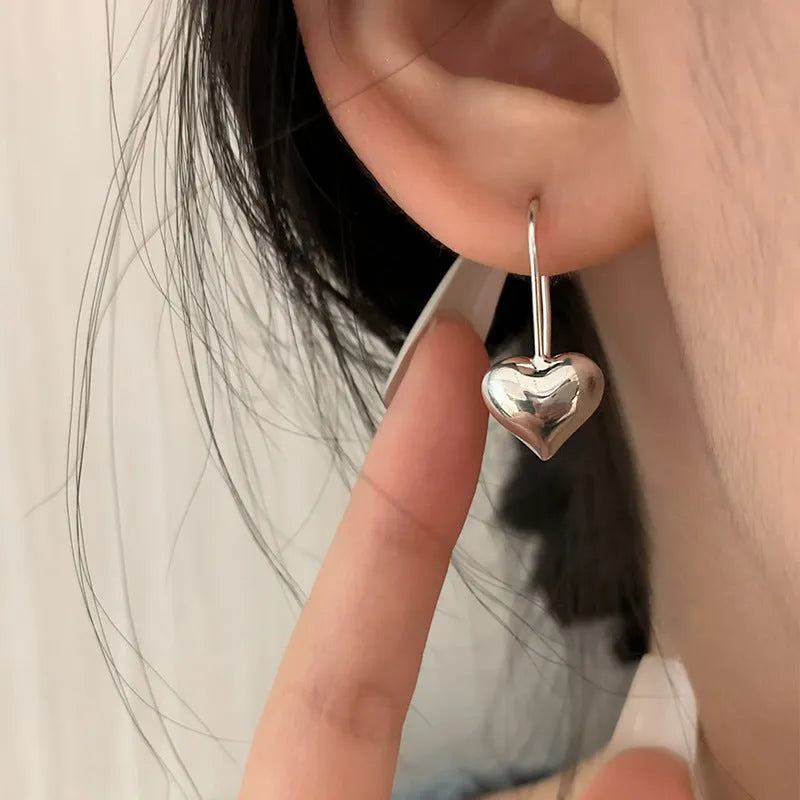 Silver heart-shaped earrings with glossy finish and ear hook fitting