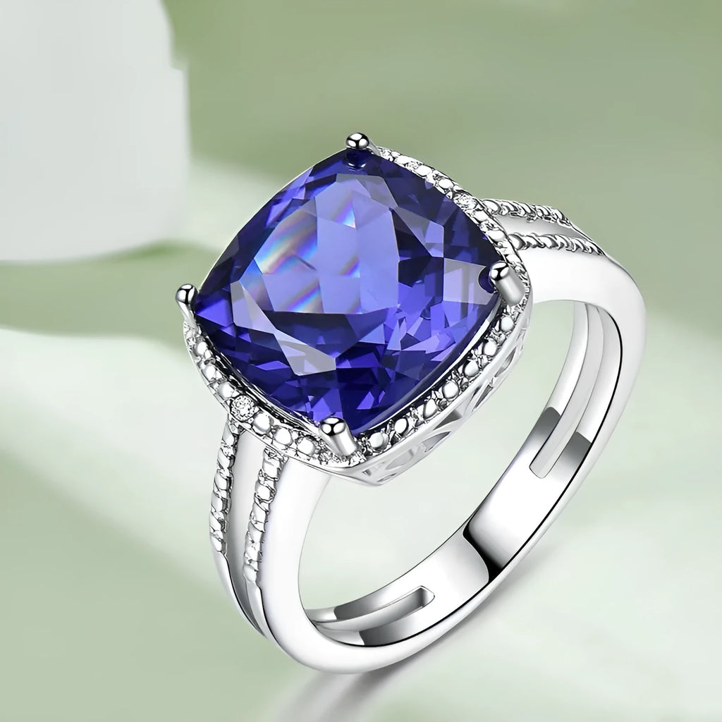 Women's sterling silver ring with a blue tanzanite gemstone on a model's hand.