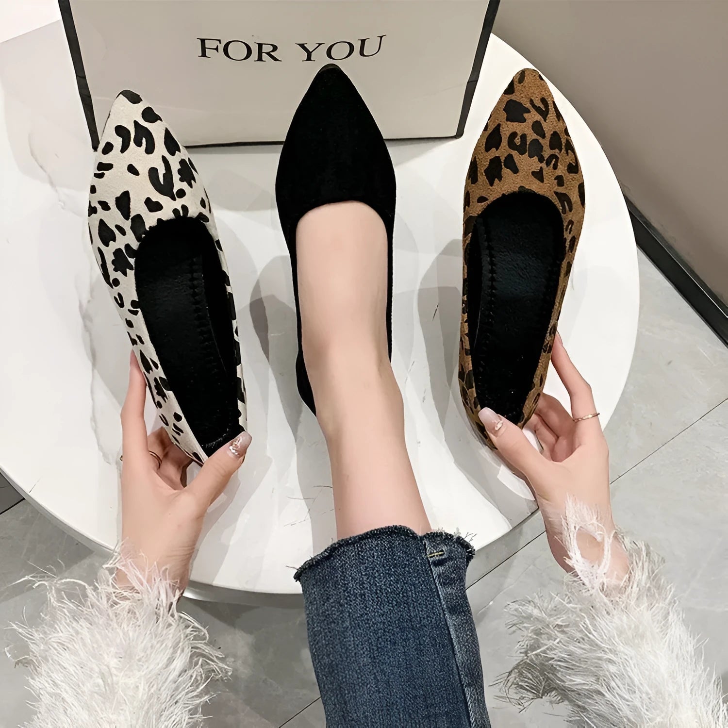 Women's flat pointed toe leopard print pumps with a low heel on a plain background.