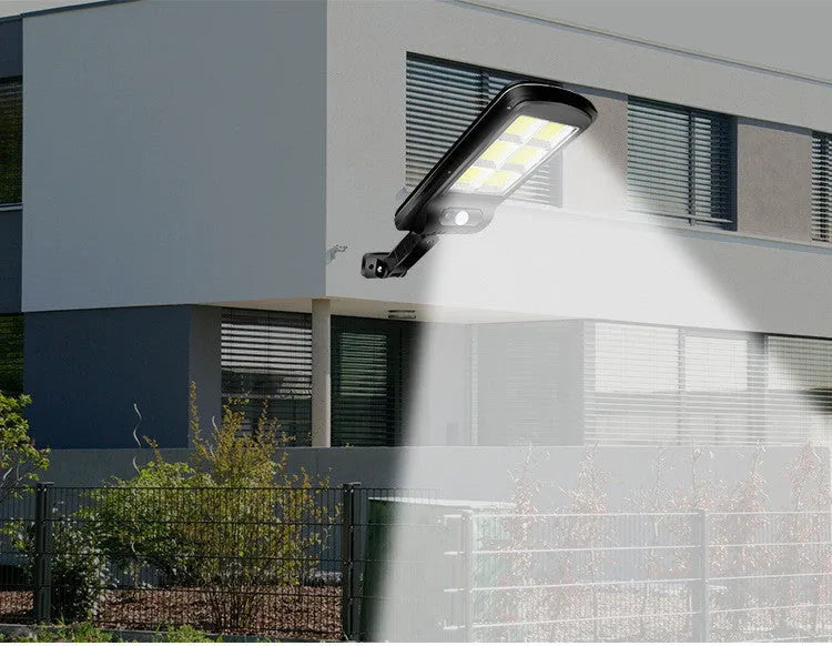 Black solar-powered outdoor security light with motion sensor mounted on a wall.