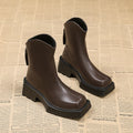 Black women's platform Martin ankle boots with a square toe and high heel on a white background